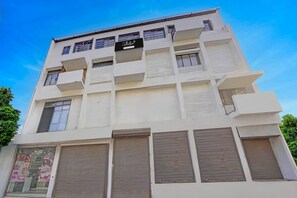 A multi-story building with a sign indicating it is a company-serviced collection. - Classic Hotel Vrundavan Residency (Vadodara)