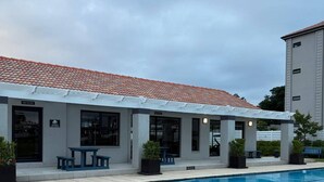 A building with a swimming pool, outdoor seating, and a covered patio area. - Apartment in Stay Near Montecasino (Johannesburg)