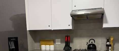 A modern kitchen with a stainless steel refrigerator, a built-in oven, and a gas stove.