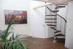 A staircase with a metal railing and a door leading to another room. - at the Schweizer holiday farm (Waltenhofen)