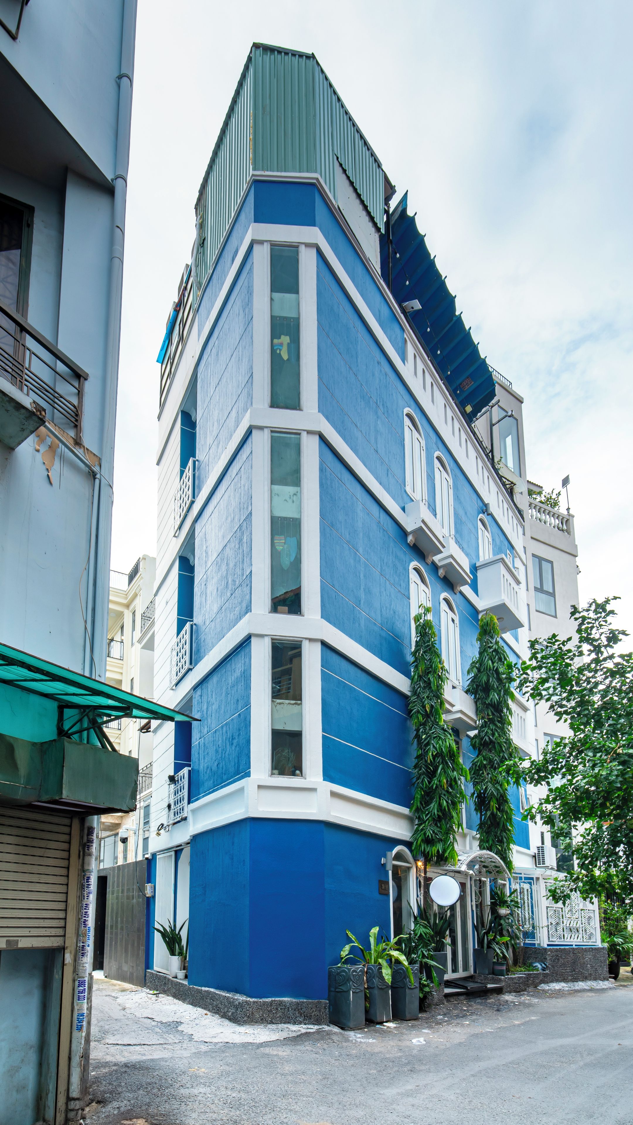 A corner building with a blue facade, multiple windows, and a visible balcony.