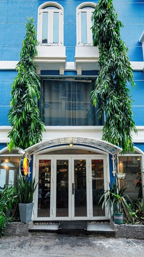 Ein Gebäude mit blauer Fassade, weißen Türen und großen Fenstern.