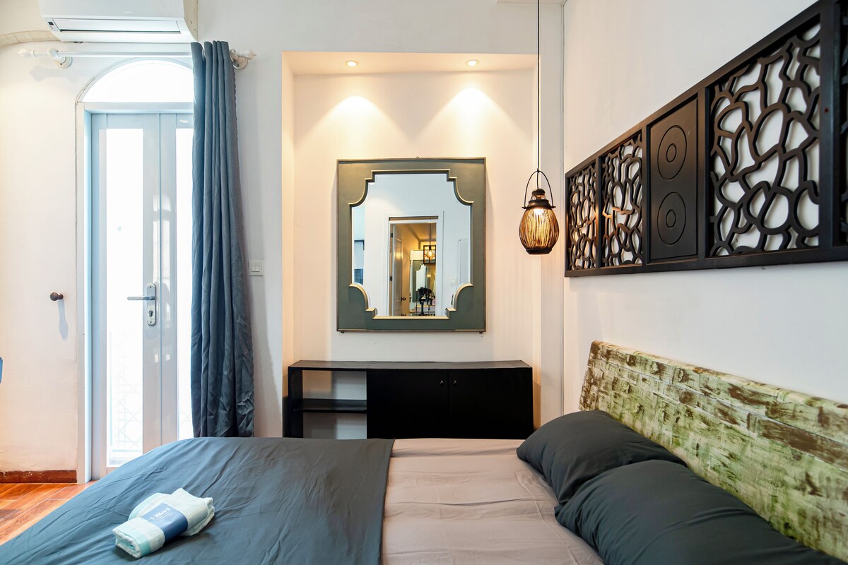 Ein Hotelzimmer mit Bett, Schreibtisch und Spiegel.