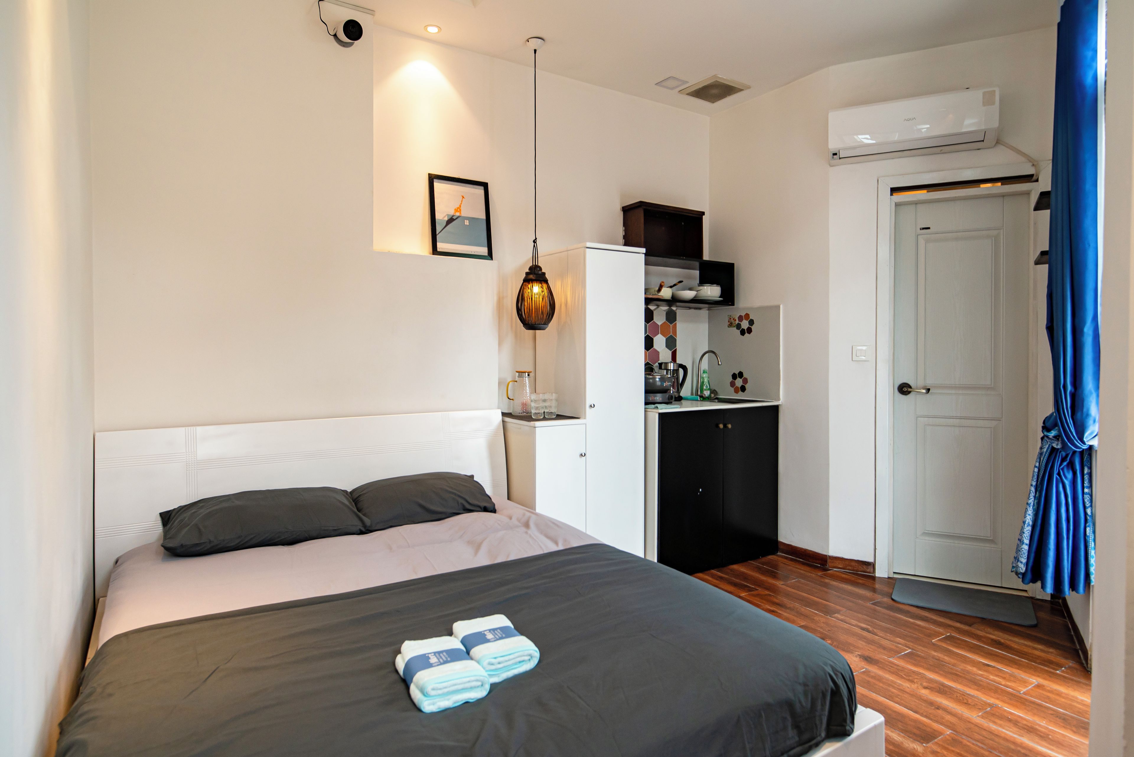 Ein Hotelzimmer mit Bett, Schreibtisch, Kleiderschrank und Klimaanlage.