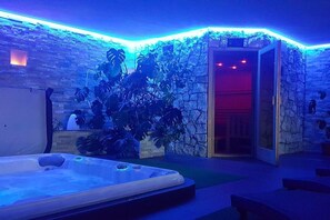 A spa area with a hot tub, stone walls, and indoor plants. - L-XL up to 12 people (ahrntal)