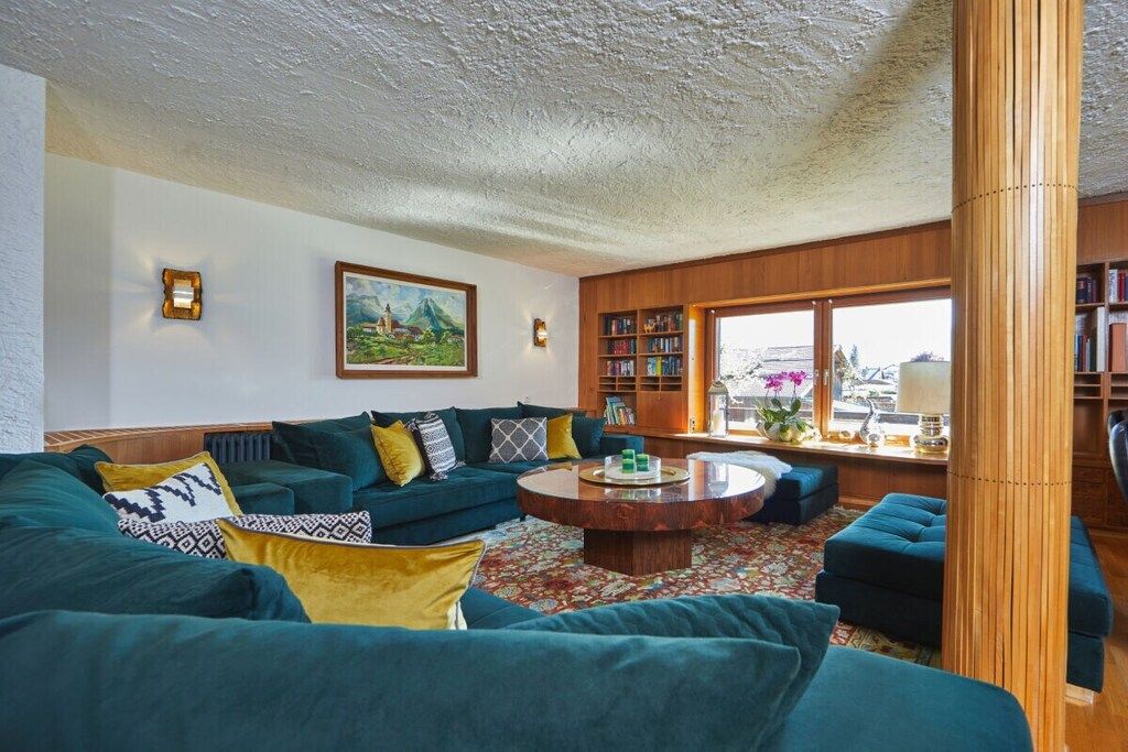 A living room with a sofa set, a coffee table, and a bookshelf.
