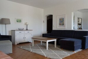 Una sala de estar con un sofá, una mesa de centro, un armario y una alfombra.