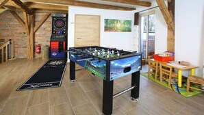A room with two foosball tables, a fire extinguisher, and a door. - Holiday home with 3 bedrooms (Viechtach)