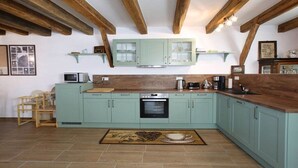 A kitchen with light blue cabinets, a wooden countertop, and a tiled floor. - Holiday home with 3 bedrooms (Viechtach)