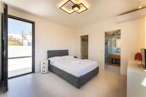 A modern bedroom with a bed, a wardrobe, a bathroom with a sink and mirror, and a ceiling light fixture. - Solemar Sicilia - Villa Mondello (Palermo)