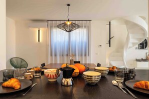 A dining area with a table set for two, featuring a variety of dishes, glasses, and cutlery. - Solemar Sicilia - Villa Mondello (Palermo)