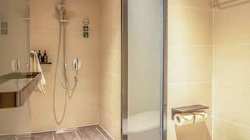 A modern bathroom with a glass-enclosed shower, a toilet, and a sink.