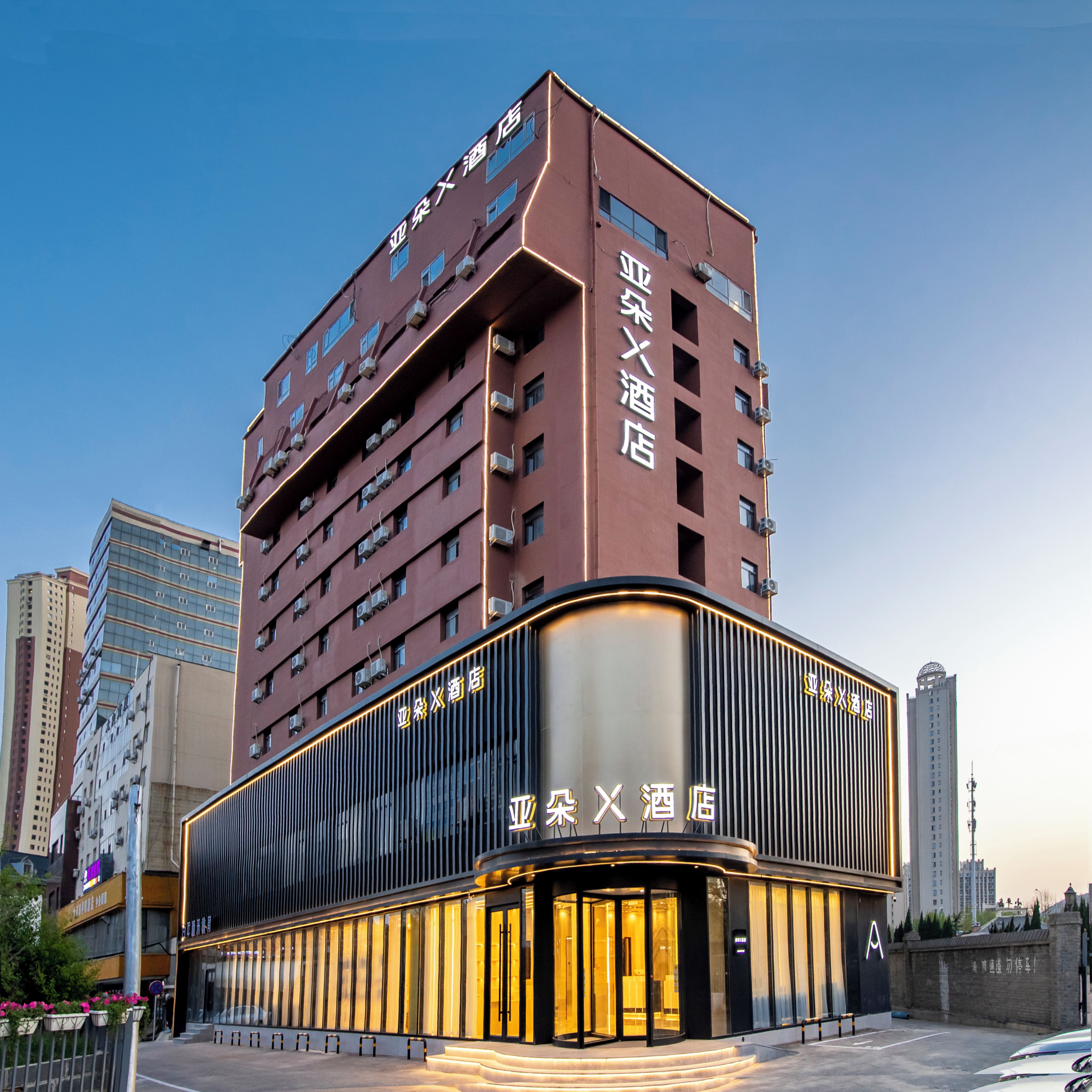 Un hotel de diverses plantes amb una entrada destacada i senyalització.