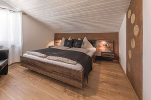 A bedroom with a wooden bed, bedside tables, and a wall with circular patterns. - Holiday home with 1 bedroom (Steinhaus)