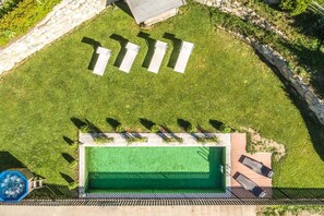 An aerial view of a swimming pool area with a deck, lounge chairs, and a small pool. - Holiday home with 1 bedroom (Steinhaus)