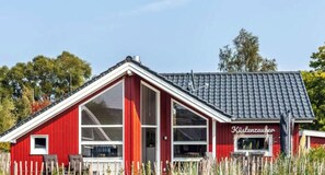 Un edificio rojo con techo inclinado y ventanas grandes, con la leyenda 'Kirstenzaufer'.