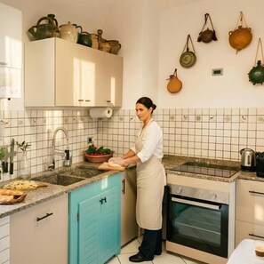 Eine Küche mit einer Person, die kocht, einem Spülbecken, einem Herd und verschiedenen Küchengeräten.
