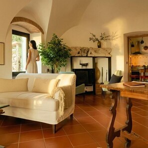 A living room with a sofa, a dining table, and a fireplace. - La Sbilenca (Calice Ligure)