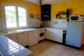 A kitchen with a window, a microwave, and cabinets. - Holiday home in Armissan with swimming pool (Armissan)