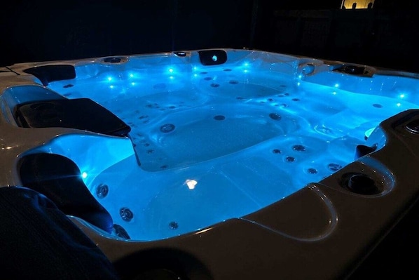 A hot tub with multiple jets and LED lighting.