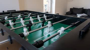 Ein Kicker mit einer grünen Spielfläche und schwarz-weißen Spielerfiguren.