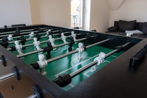 A foosball table with a green playing surface and black and white player figures.