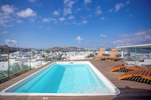 A rooftop pool with a clear view of a coastal town. - Vastao Luxury Residences (Mykonos)