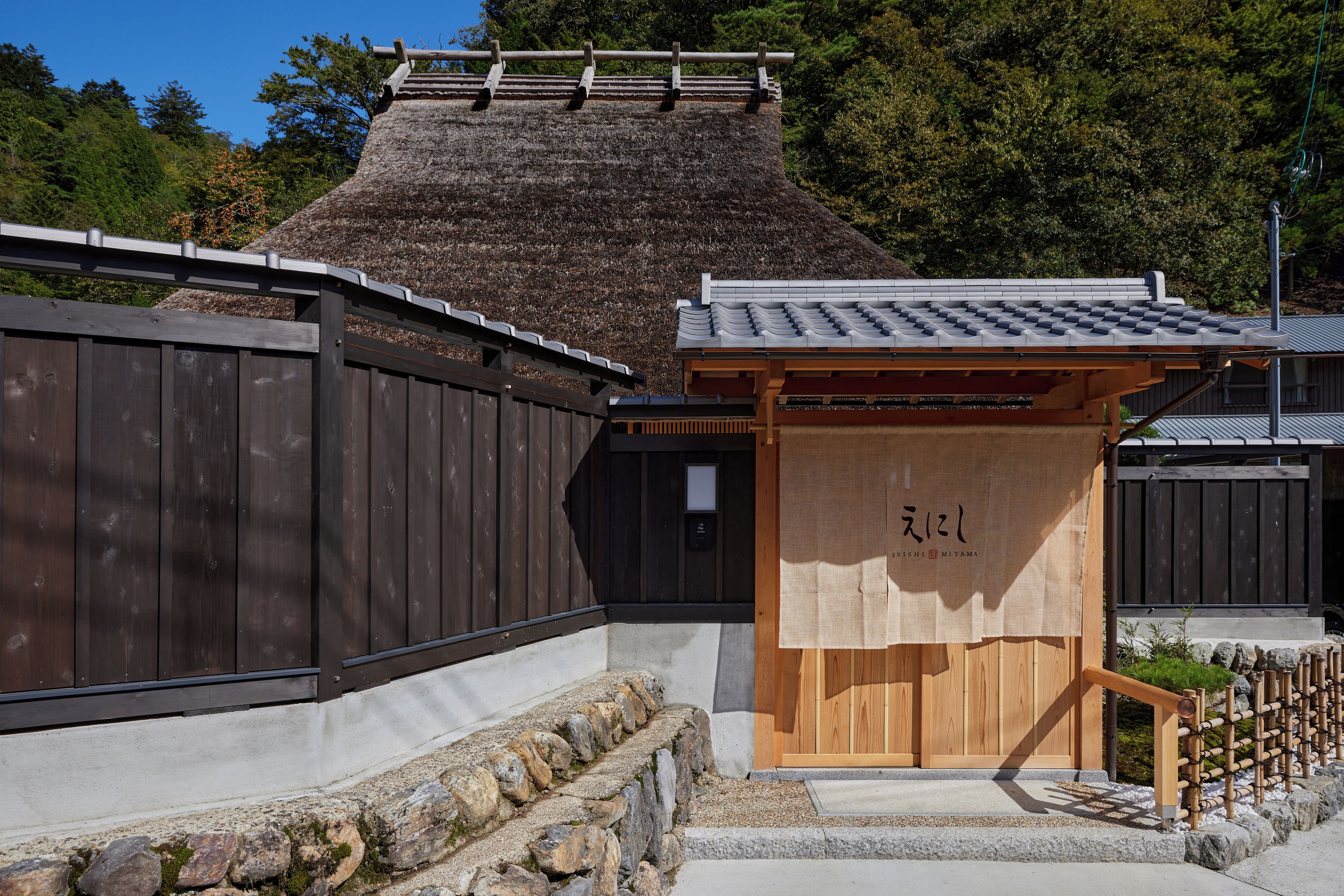A traditional Japanese building with a wooden entrance and a thatched roof.
