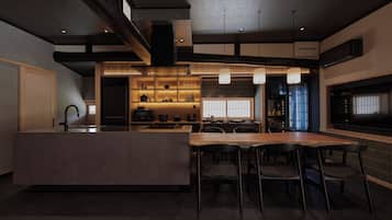A modern kitchen with a central island, bar stools, and pendant lighting.