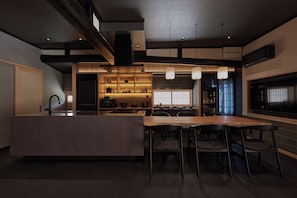 A modern kitchen with a central island, bar stools, and pendant lighting. - ENISHI MIYAMA -Kagetsu- (Nantan)