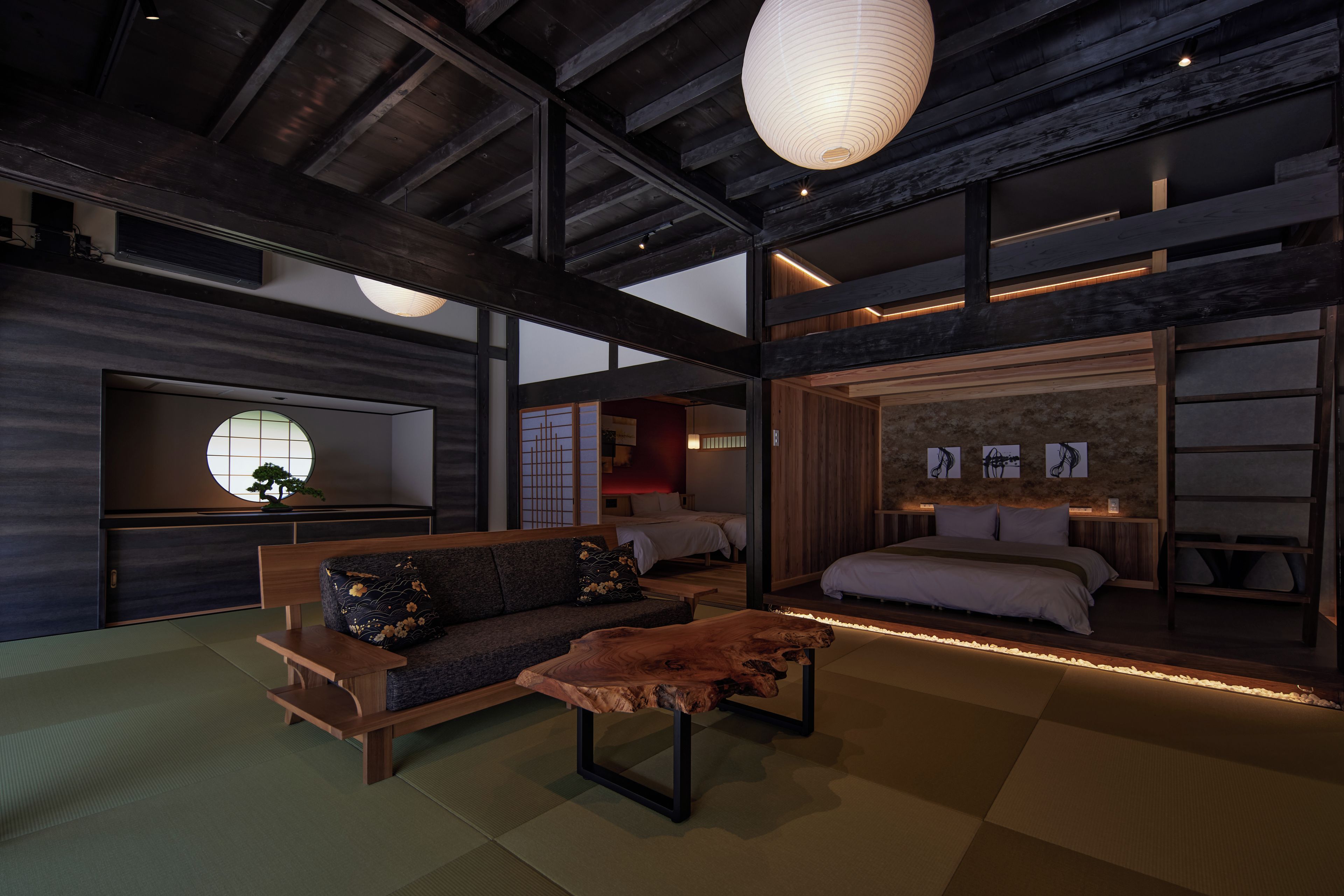 A modern interior with a sofa, a wooden coffee table, and a bed with a headboard.