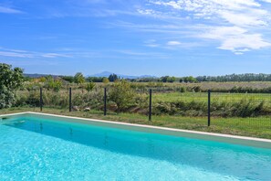 A swimming pool with a clear view of a fenced garden and distant mountains. - Holiday Home 'Les Demeures Du Soleil - Le Ventoux' with Pool, Wi-Fi and Air Conditioning (Piolenc)