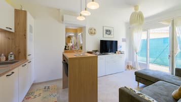 A compact living space with a kitchenette, a dining area, and a seating area with a view.
