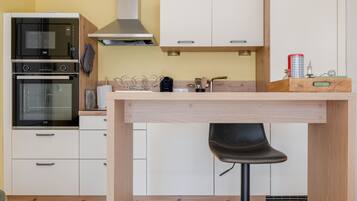 Een moderne keuken met een inbouwoven, magnetron en koffieapparaat.