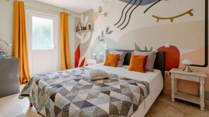Una camera da letto con un letto, un comodino, una lampada e una finestra con tende.