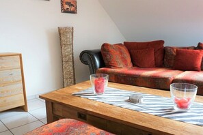 A cozy living area with a wooden coffee table, a patterned sofa, and a tall decorative vase. - Holiday apartment with 3 bedrooms (Meersburg)