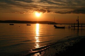 A sunset over a calm body of water with boats and a pier. - Holiday apartment with 3 bedrooms (Meersburg)