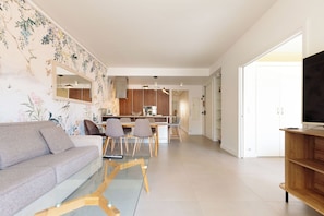 A modern living room with a sofa, a glass coffee table, and a dining area with chairs. - Apartment in Cannes with 2 bedrooms sleeps 4 (Cannes)