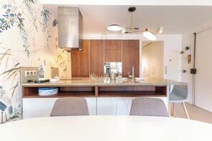 A modern kitchen with a central island, wooden cabinets, and a built-in oven. - Apartment in Cannes with 2 bedrooms sleeps 4 (Cannes)