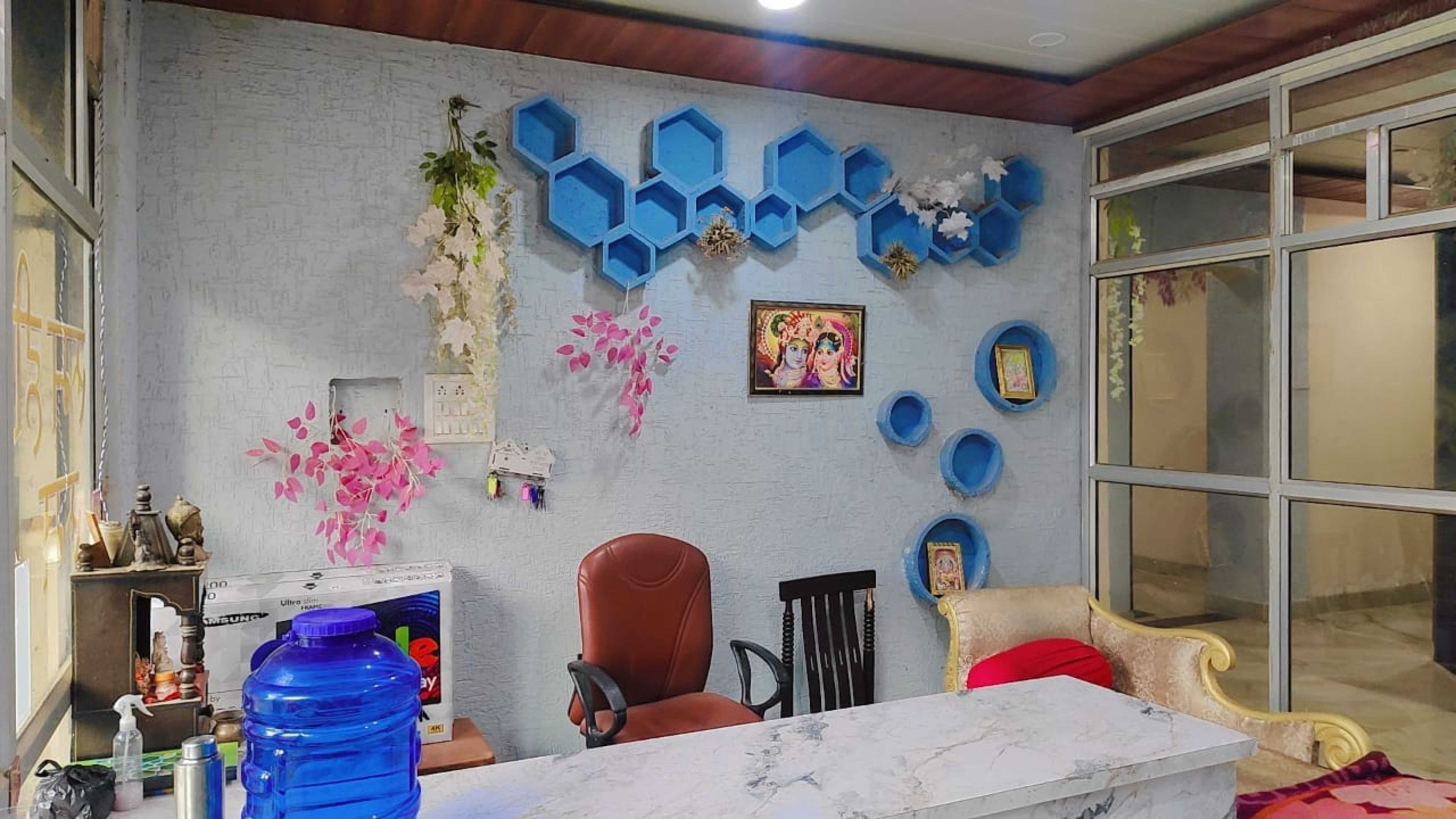 Una habitación con una mesa de mármol, una silla roja, un sofá y un dispensador de agua grande.