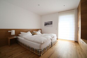 A bedroom with a bed, bedside table, and a view of the outside. - Holiday apartment with 2 bedrooms (Bodolz)