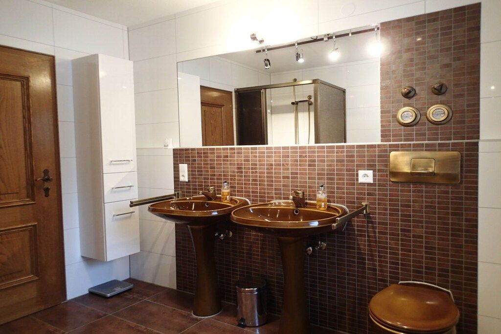 A bathroom with two sinks, a toilet, a shower, and a mirror.