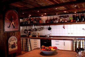 Eine Küche mit weißen Schränken, einer Holz Arbeitsplatte und verschiedenen Küchengeräten und Utensilien.