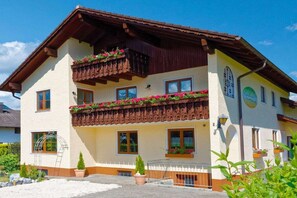Un edificio di due piani con un balcone, finestre e un cartello.