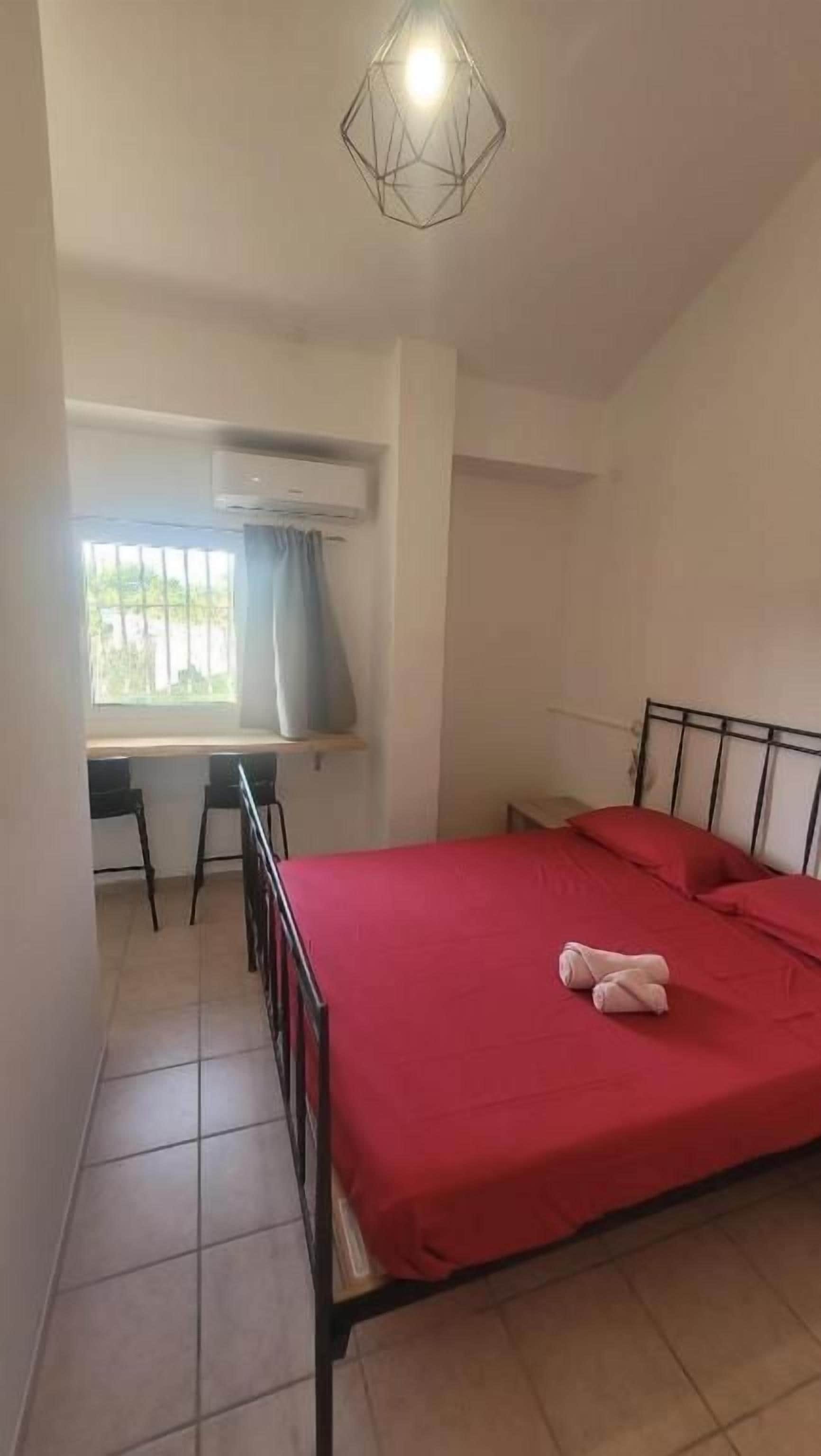 A bedroom with a bed, a desk, and a chair.