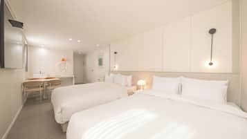 Habitación de hotel con dos camas, un escritorio, una silla y un espejo.
