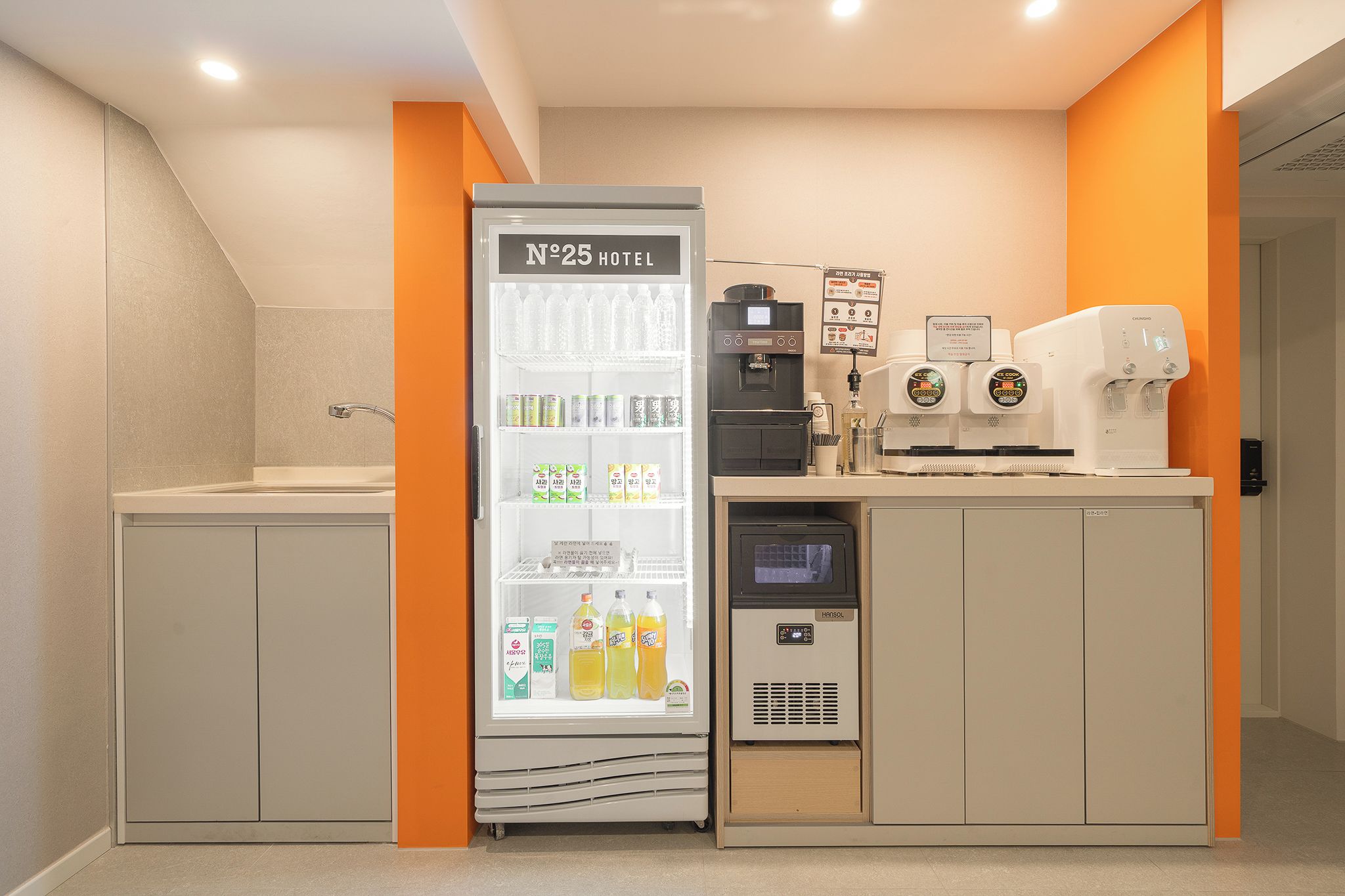 A kitchenette area with a refrigerator, coffee machines, and a microwave.
