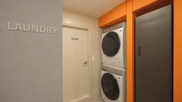 A laundry room with a door labeled 'TOILET' and a washing machine.