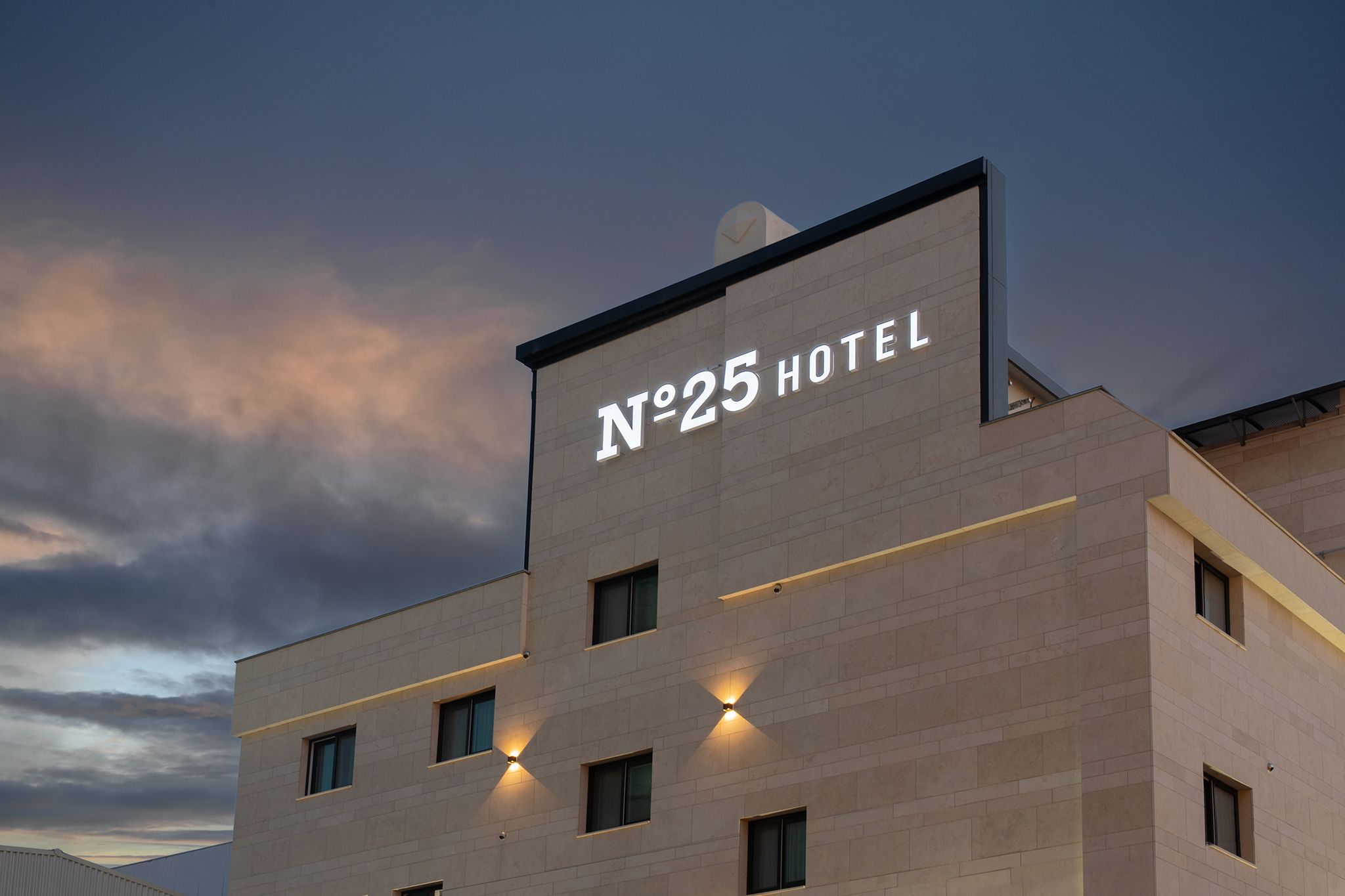 Un edificio de hotel con un letrero que dice 'N°25 HOTEL' y varias ventanas.