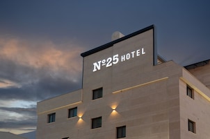 A hotel building with a sign reading 'N°25 HOTEL' and multiple windows.